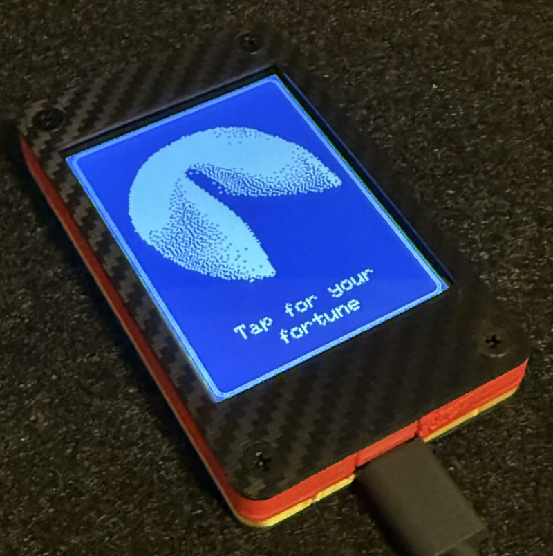 A photograph of the fortune cookie device, a small rectangle with a touchscreen.